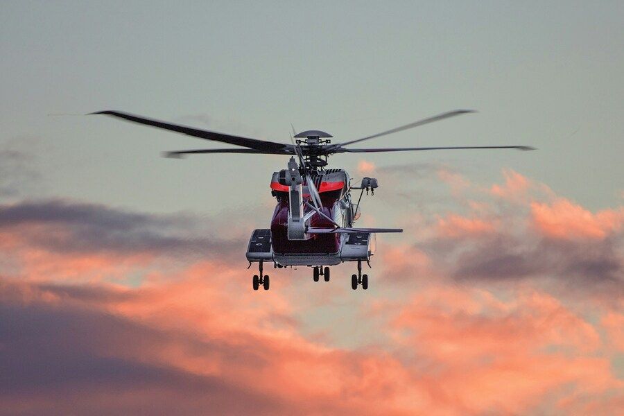 Ein Helikopter fliegt am Abendhimmel