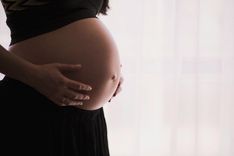 Eine schwangere Frau hält ihren Babybauch