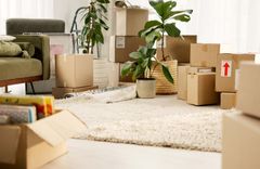 Aufnahme eines Wohnzimmers, in dem Umzugskartons stehen.